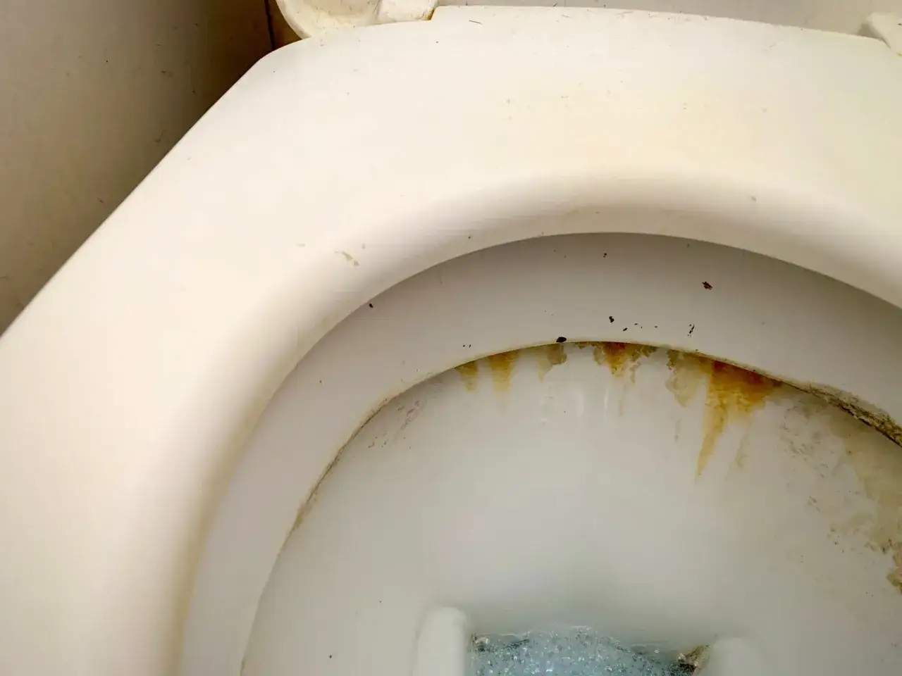 Gouttes jaun&acirc;tres et traces de tartre wc sur la c&eacute;ramique blanche.