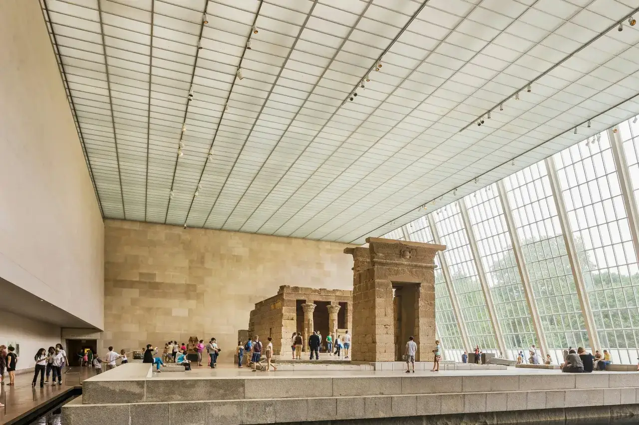 Zwiedzający podziwiają egipską świątynię w Met w Nowym Jorku. Ogromne okna wpuszczają światło do muzeum.