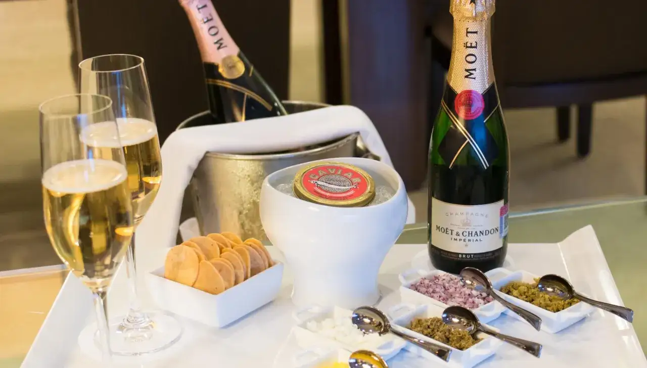 Stuzzichini per aperitivo con champagne Moët & Chandon: caviale, crostini, cipolla rossa tritata e altri condimenti.