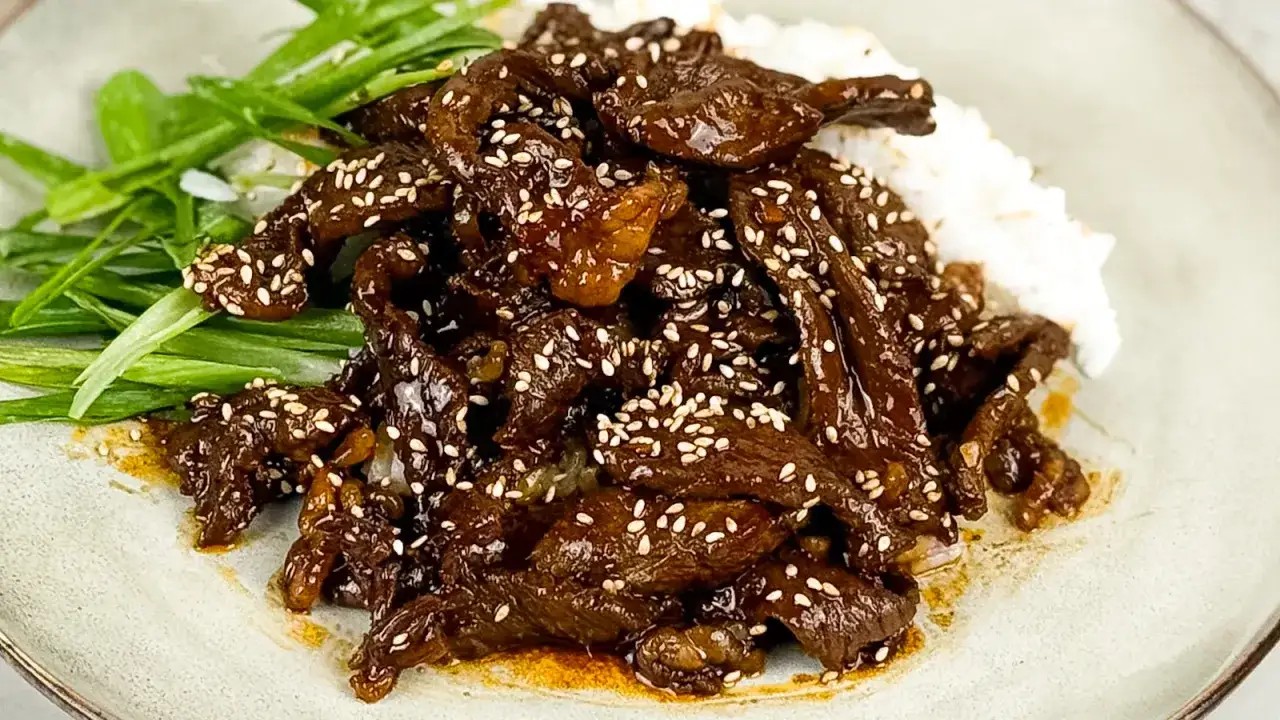 En läcker yakiniku-rätt med strimlat kött, sesamfrön och ris, garnerad med salladslök. Ett perfekt yakiniku recept för en smakrik middag.