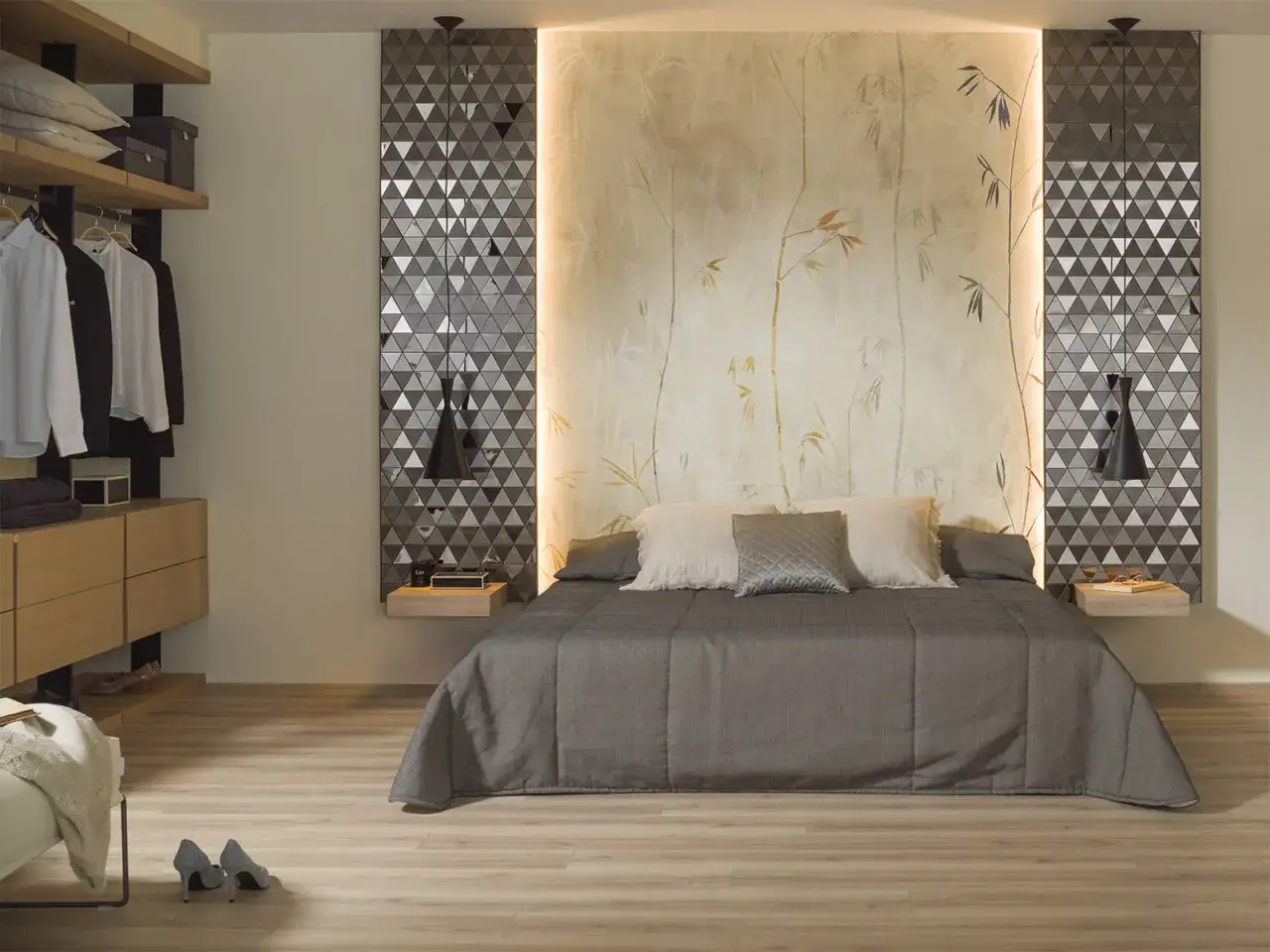Habitaciones sin cabecero: cama con edred&oacute;n gris, almohadas y papel tapiz de bamb&uacute;. A la izquierda, armario abierto con ropa.