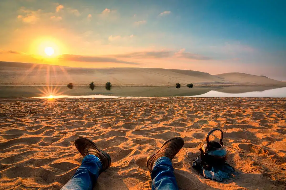 Atardecer en el desierto, con dunas, un lago y una tetera. La mejor época para ir a Egipto es cuando el sol se pone así.