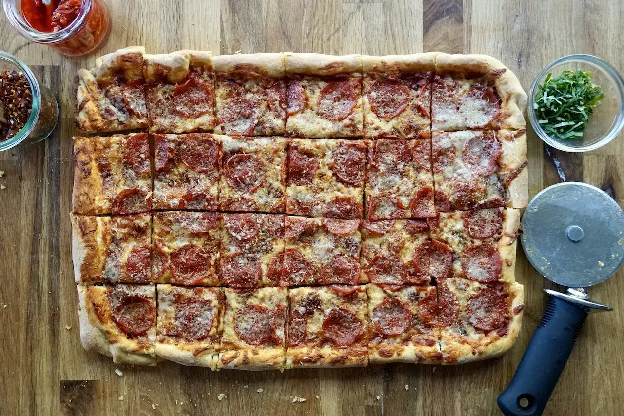 Domowa pizza na blachę z pepperoni, idealna na rodzinny obiad. Przepis na ciasto ze świeże drożdże.
