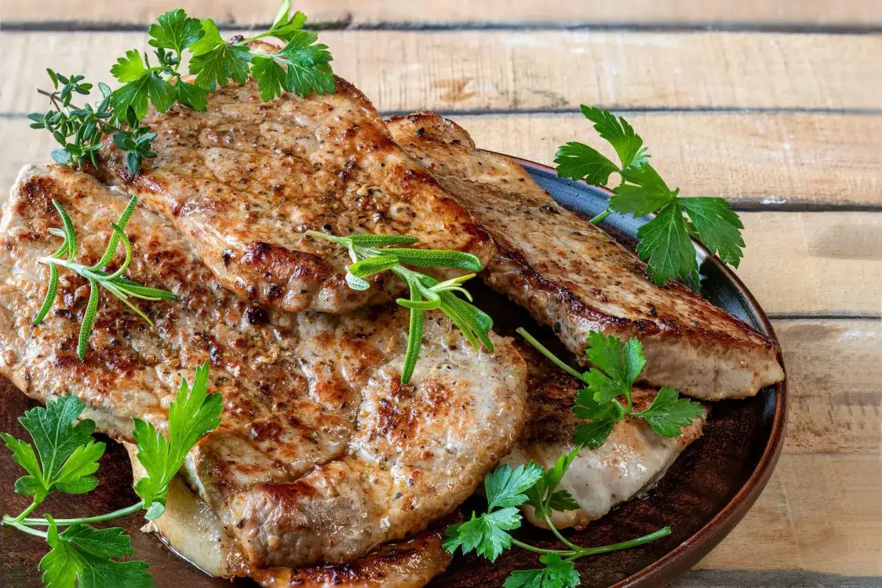 Soczysty schab z airfryer, przyprawiony ziołami, podany na talerzu. Idealny na obiad.