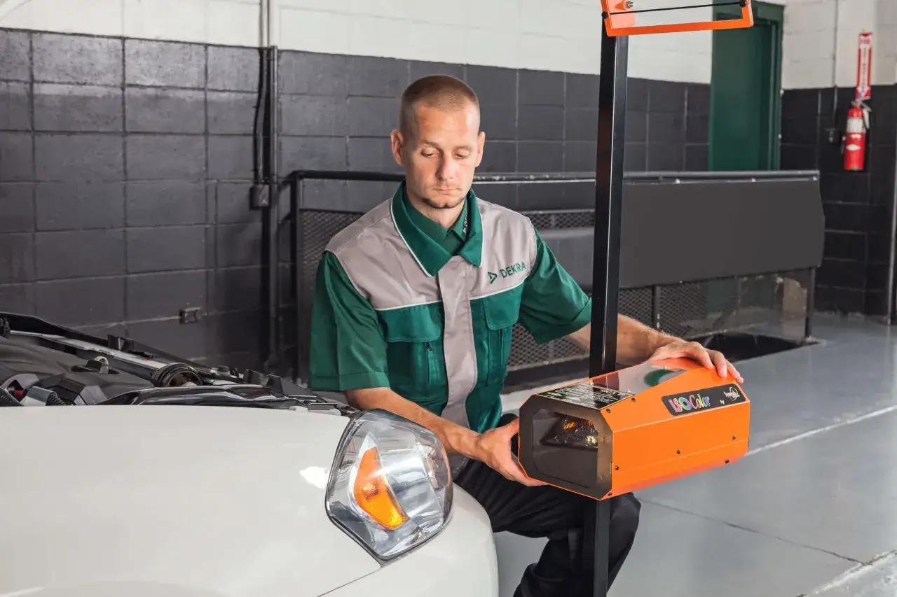 Técnico ajustando un dispositivo para cambiar halógeno por led en un coche.