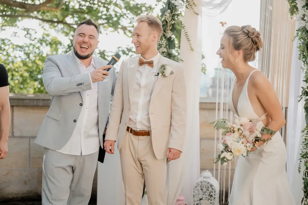 Śmiech pary młodej i świadka podczas ślubu. Świadek zadaje pytania do dj, a wszyscy świetnie się bawią.