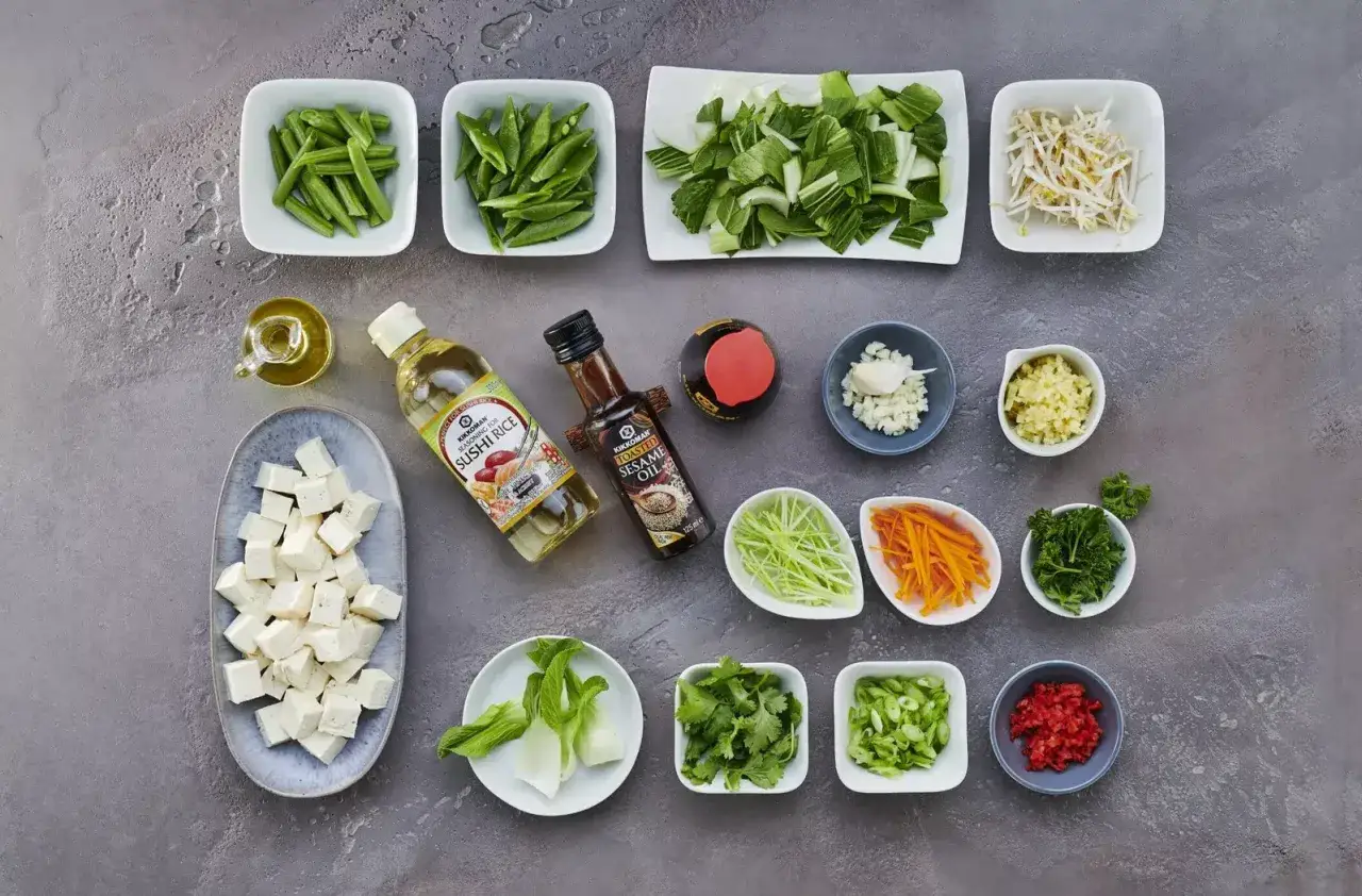 Składniki do stir fry: pokrojone tofu, fasolka szparagowa, groszek cukrowy, pak choi, kiełki fasoli mung, marchewka, szczypiorek, czosnek, imbir, kolendra, chili i sosy.