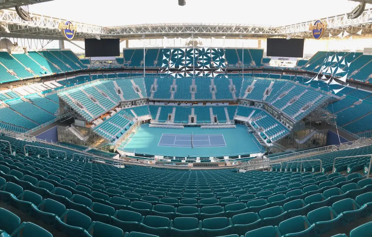 Estadio listo para el tenis torneo de Miami. Cancha azul, gradas vacías y el sol brillando.