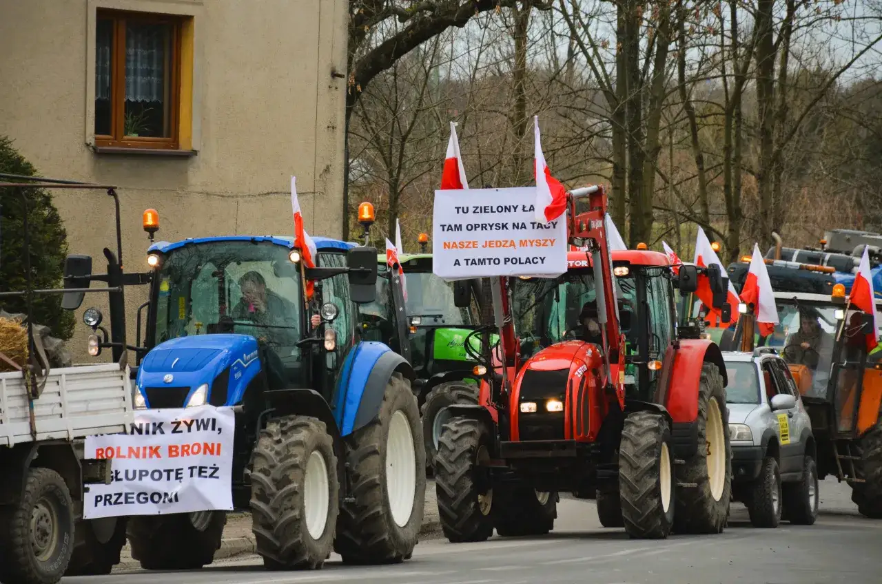 Ciągniki z polskimi flagami i transparentem 