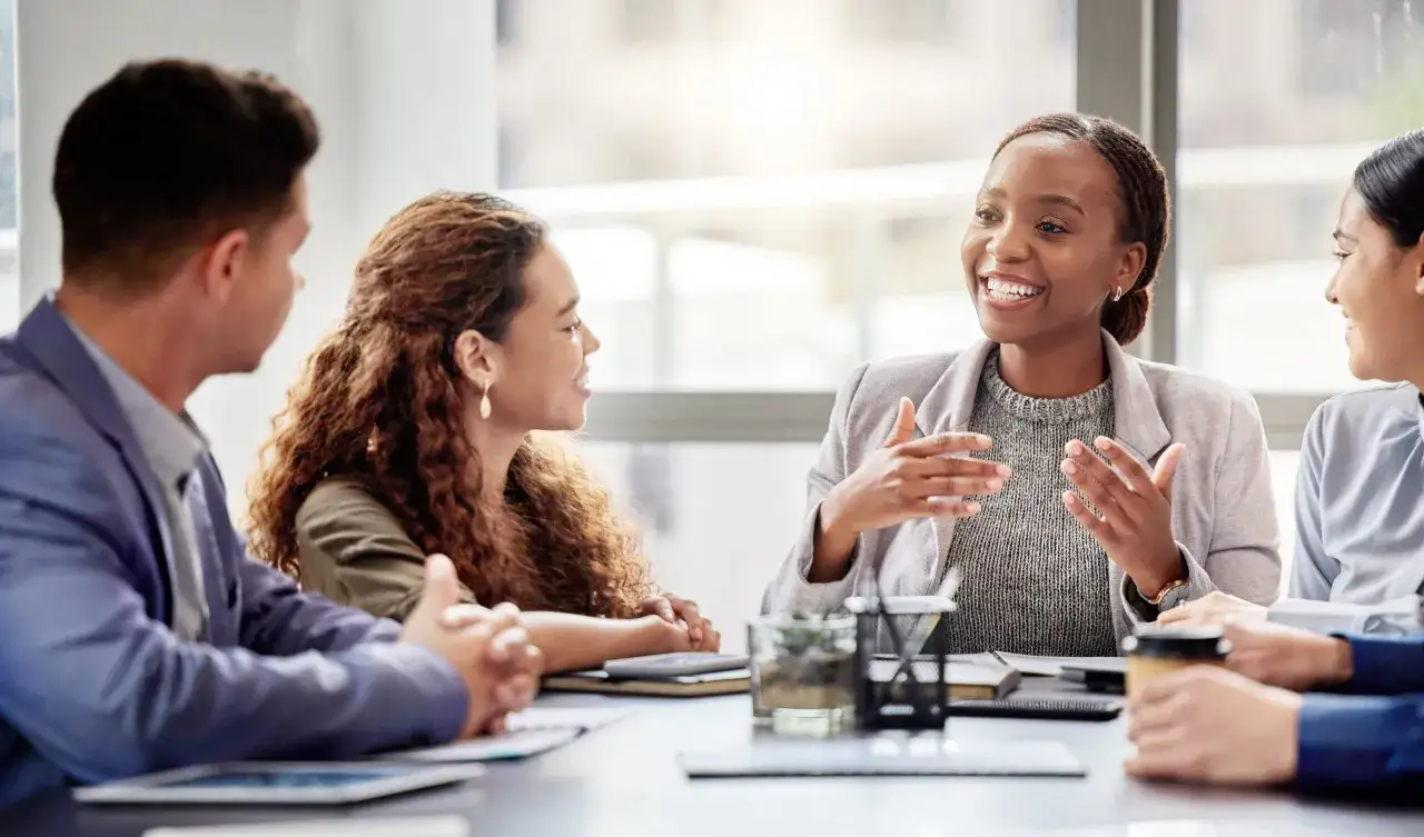 A diverse team collaborates on a strategic project, discussing plans and ideas around a table.