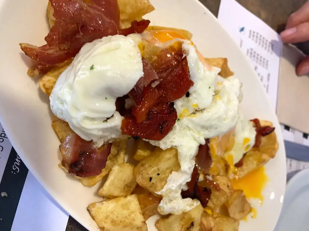 Delicioso plato de patatas, huevos escalfados y jamón serrano, típico de los furanchos de Pontevedra.