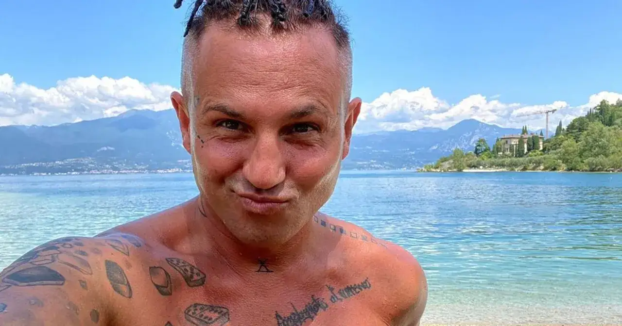 Andrzej Wierzbicki fryzjer, z tatuażami na ciele, pozuje nad jeziorem. Ile ma lat?