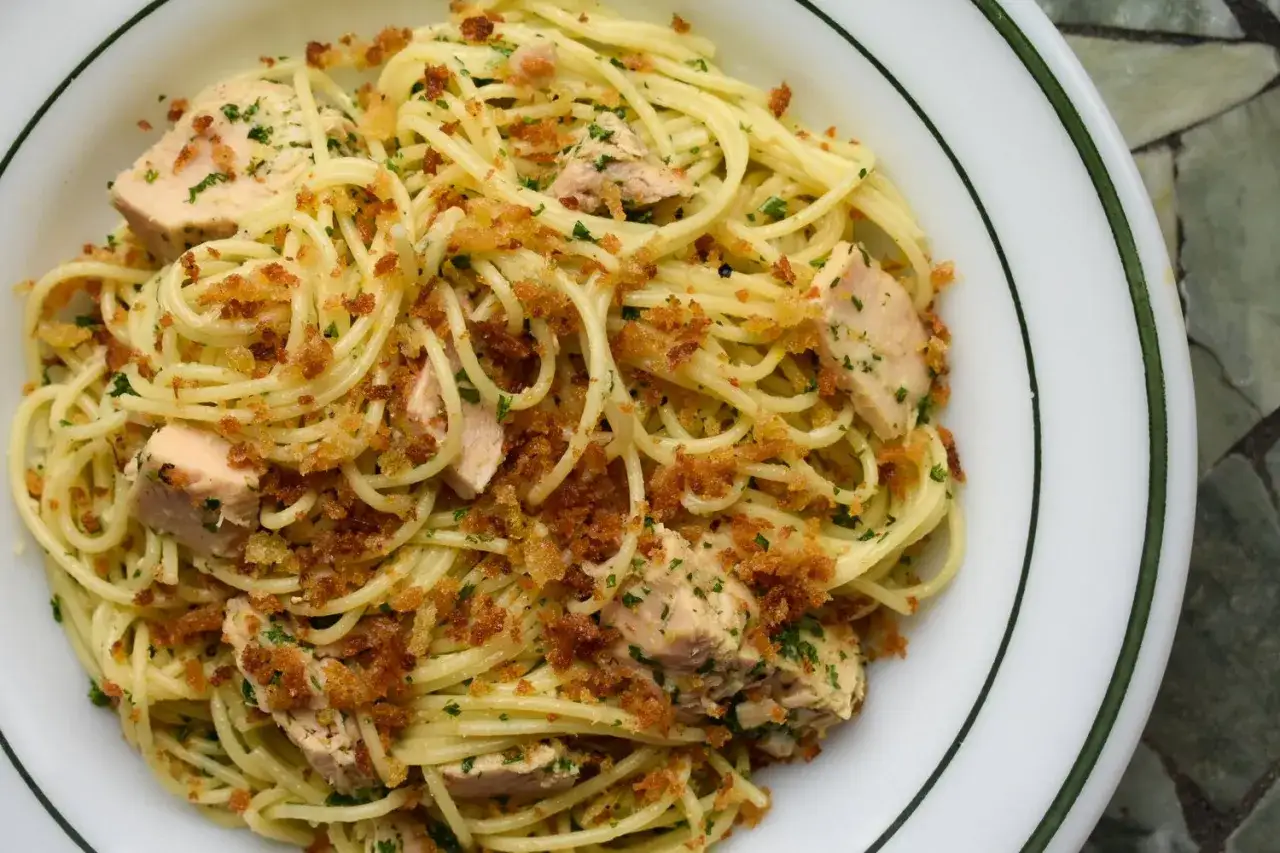 En skål med spaghetti med tonfisk, ströbröd och persilja. Ett enkelt och gott pasta al tonno recept.