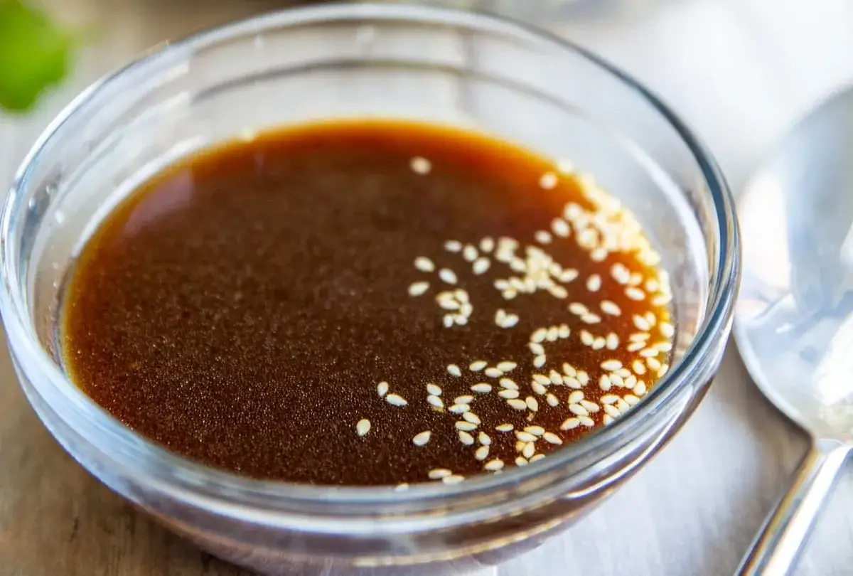 Ein Glas mit asiatischem Salatdressing, verfeinert mit Sesam. Perfekt für einen frischen Salat.