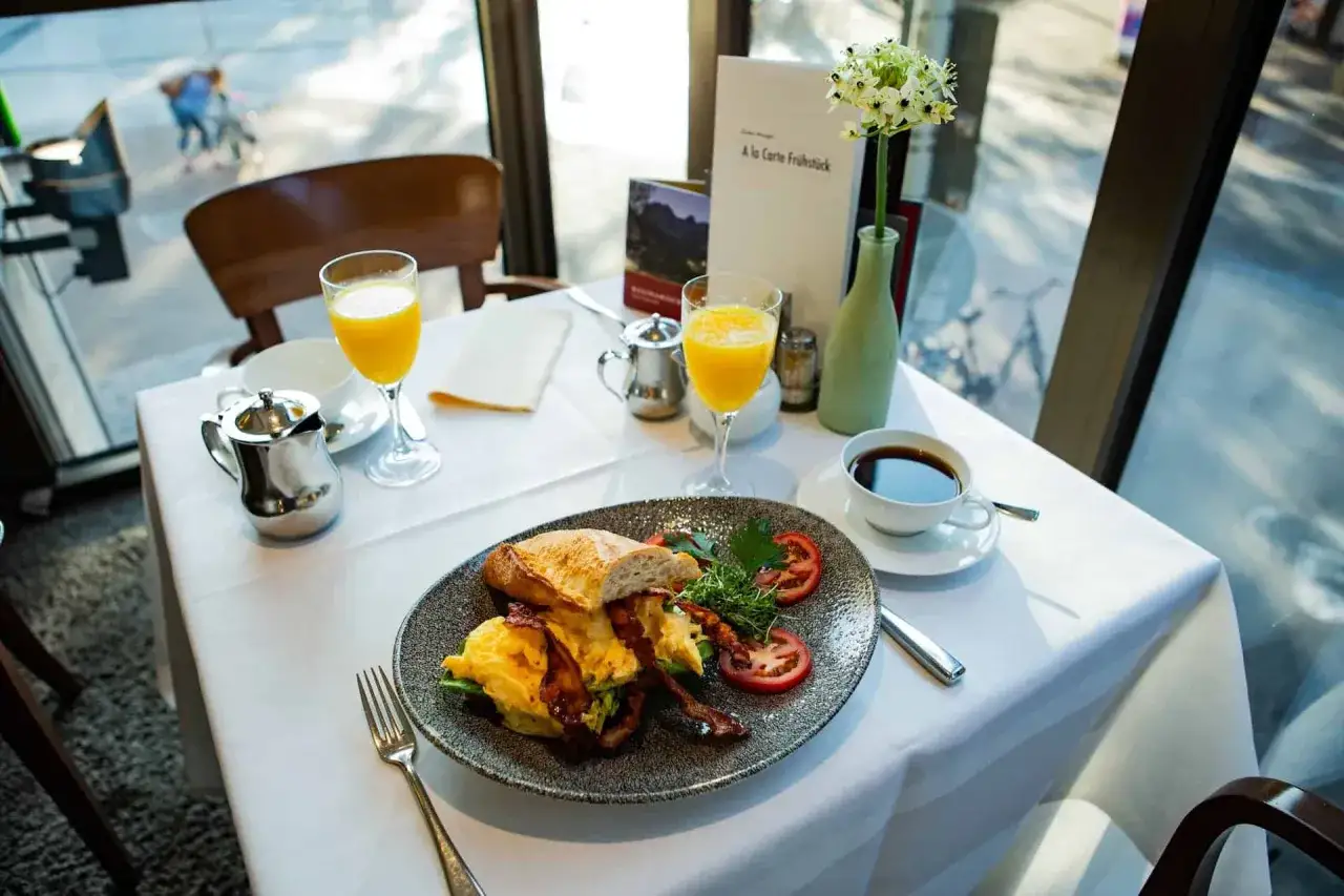 Fr&uuml;hst&uuml;ck im Cafe Central G&ouml;rlitz: R&uuml;hrei, Speck, Baguette, Orangensaft und Kaffee.