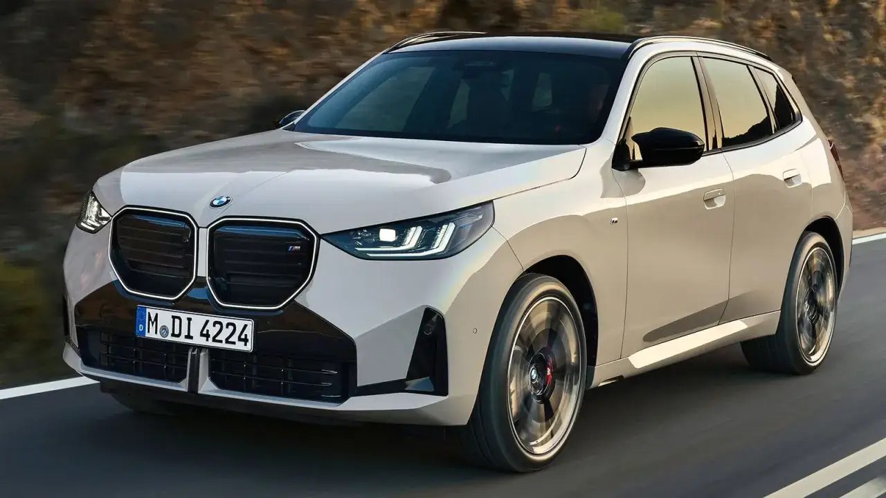 Nowe BMW X3 w kolorze beżowym, z czarnym dachem, pędzi po drodze. Zastanawiasz się, ile kosztuje BMW X3?