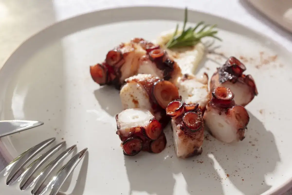 Tentacoli di polpo grigliati, un assaggio dei piatti tipici foggiani, serviti con pur&egrave; e rosmarino.