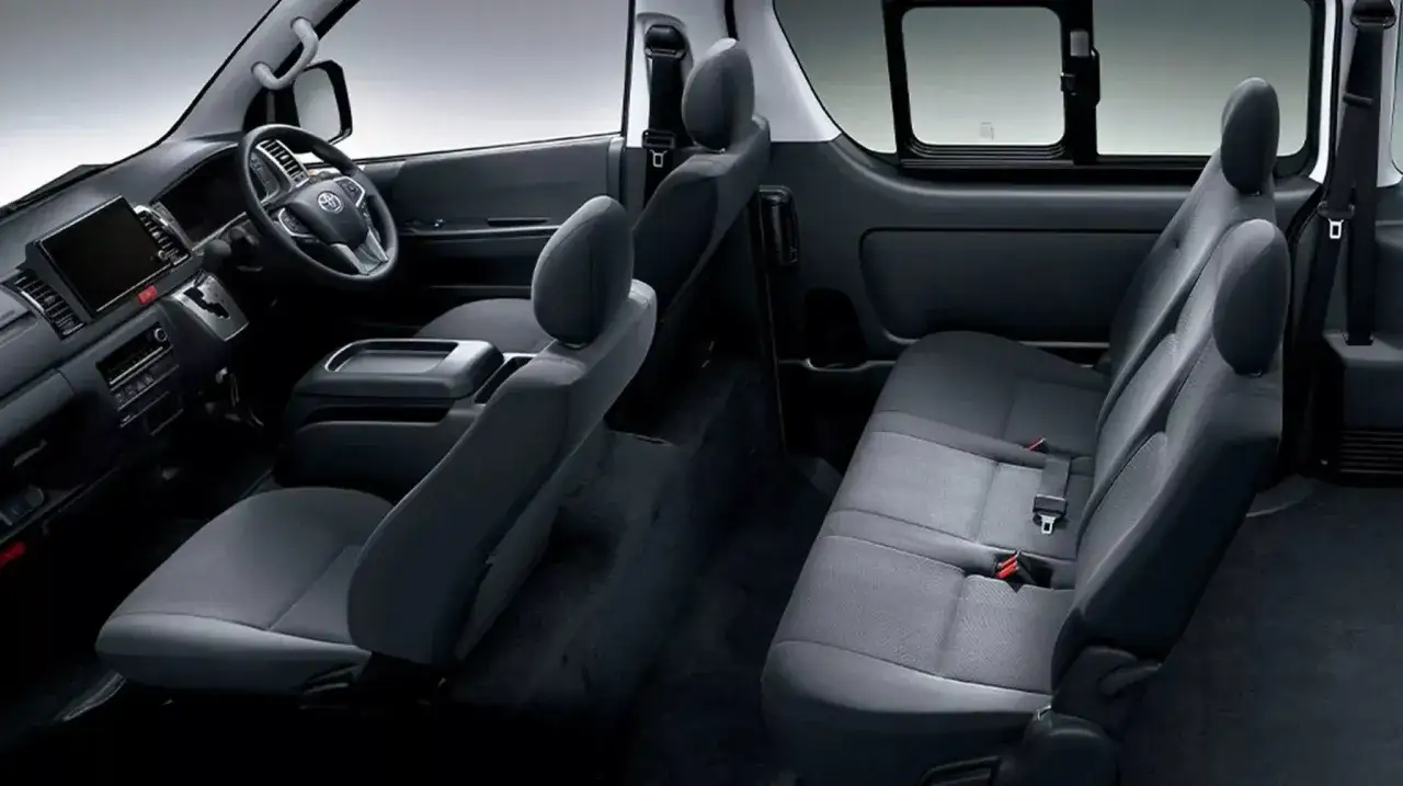 Wnętrze Toyoty Hiace z wygodnymi siedzeniami dla pasażerów i kierowcy.