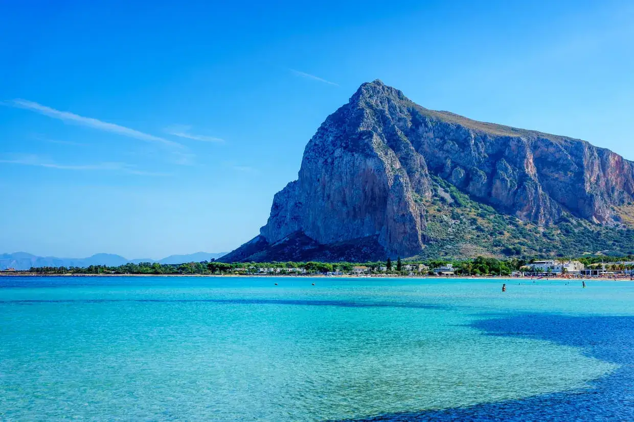 Vue magnifique sur la mer turquoise et la montagne imposante de Capo San Vito, avec une plage anim&eacute;e en arri&egrave;re-plan.