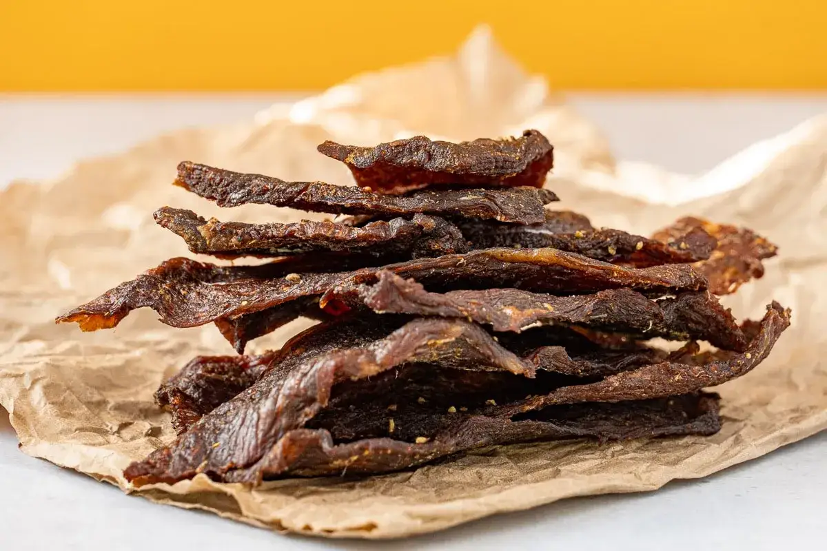 Stapel von selbstgemachtem Beef Jerky auf Packpapier. Perfekt f&uuml;r Snacks, wenn man Beef Jerky selber machen m&ouml;chte.