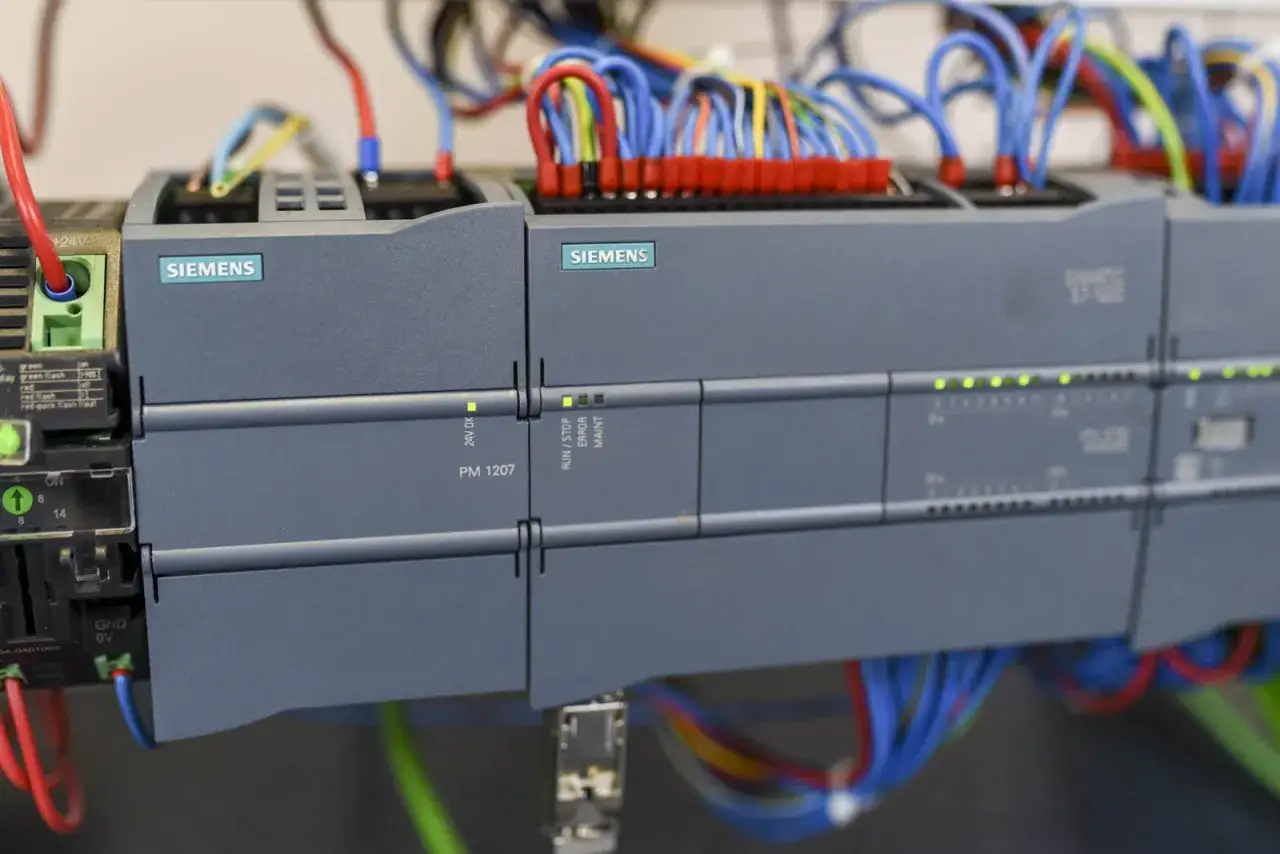 Moduły Siemens S7-1200, gotowe do programowania PLC. Widać przewody zasilające i sygnałowe.