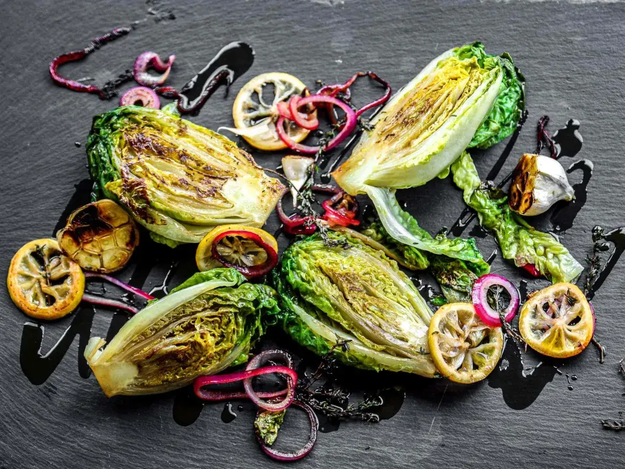 Gegrillter Romanasalat mit Zitronenspalten, roten Zwiebeln und Knoblauch – ein einfaches, aber köstliches Romanasalat Rezept.