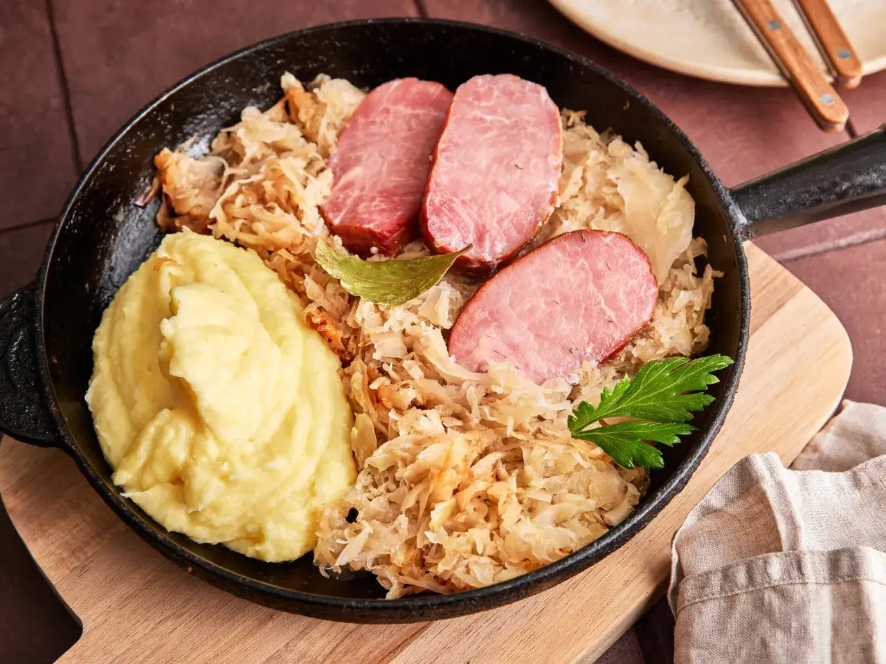 Kassler in Sauerkraut mitkochen wie lange? Herzhaftes Gericht mit Kartoffelp&uuml;ree, Kassler und Sauerkraut in einer Pfanne.