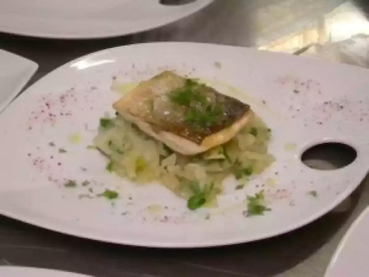 Un filet de bar au four, peau croustillante, servi sur un lit de légumes tendres. Un plat élégant et savoureux.