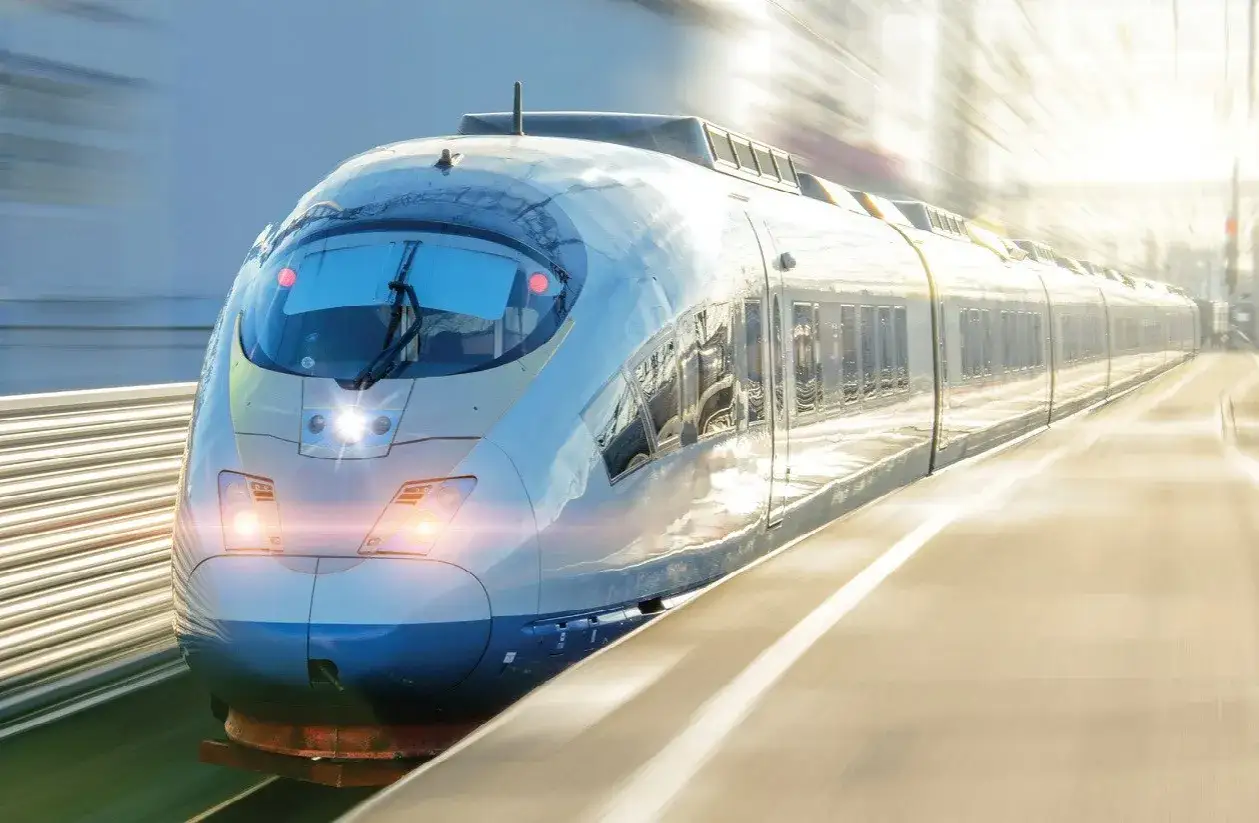 Szybki pociąg, jak ERTMS ETCS, mknie po torach, rozmywając krajobraz.