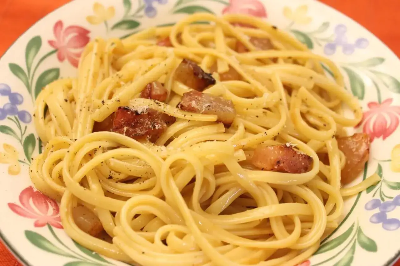 Ein Teller mit Spaghetti Carbonara, authentisch italienisch, mit knusprigem Guanciale und frisch geriebenem Pecorino.