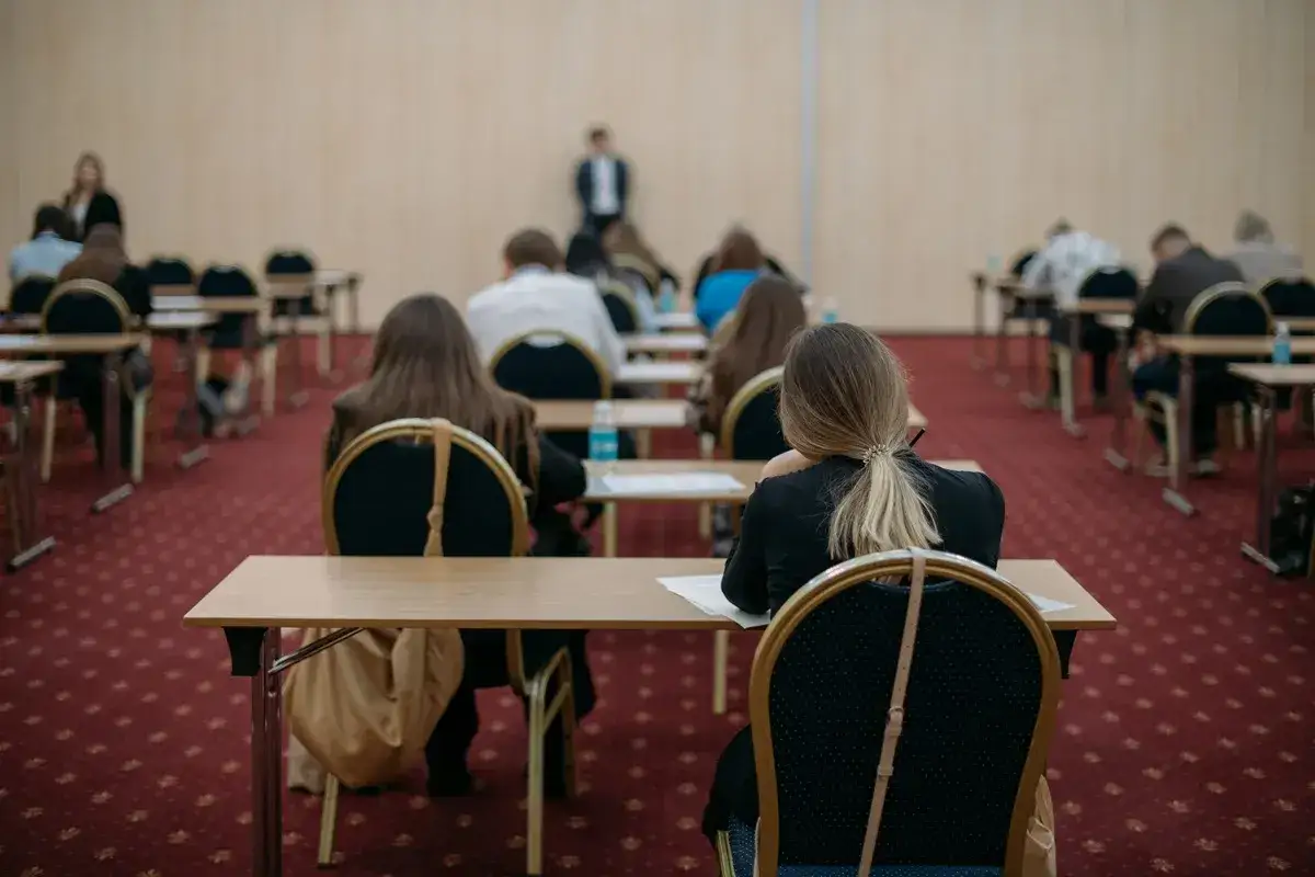 Uczniowie siedzą w rzędach, skupieni na zadaniach. To może być dzień, w którym piszą **maturę poprawkową**, mając nadzieję na lepszy wynik.
