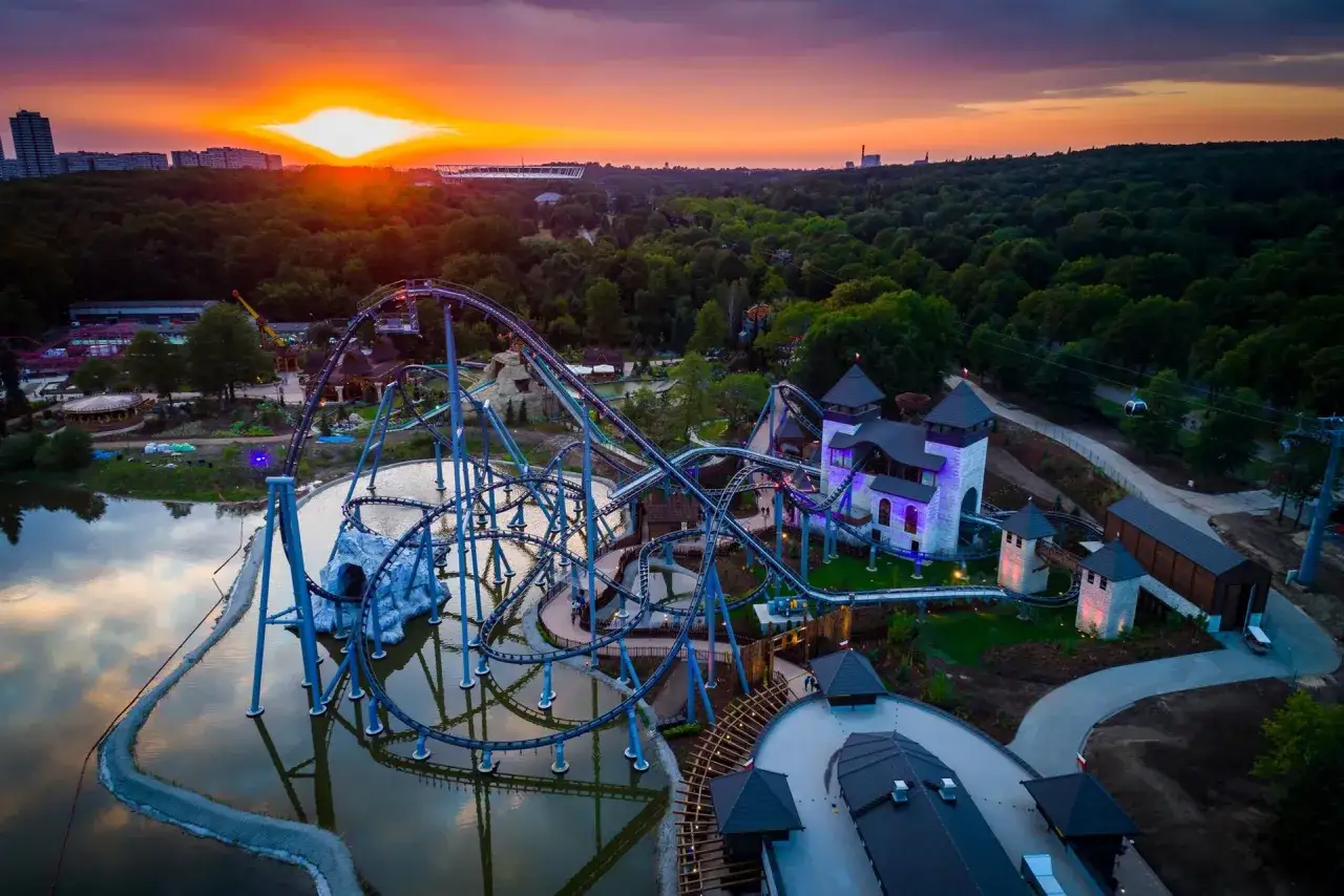 Zachód słońca nad Parkiem Chorzowskim. Widok na roller coaster i zamkowe atrakcje, które zachwycają o każdej porze dnia.