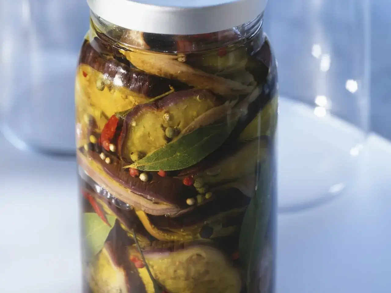 Eingelegtes Gemüse im Glas: Auberginen haltbar machen mit Kräutern, Chili und Pfefferkörnern in Öl.