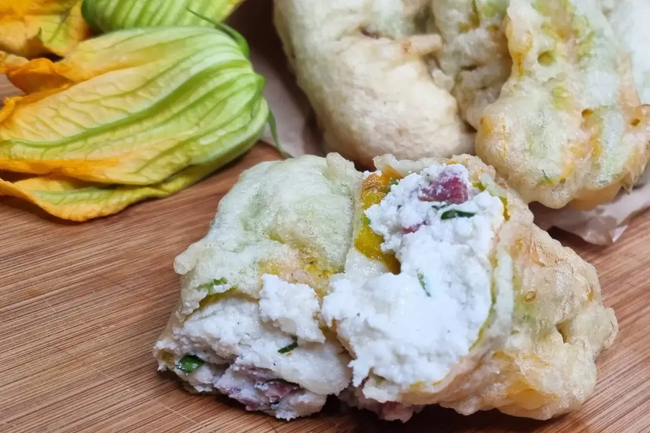 Fiori di zucca ripieni, dorati e croccanti, con un ripieno cremoso di ricotta e erbe aromatiche.