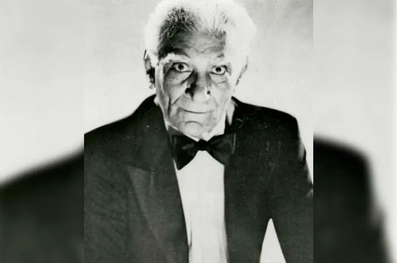 Ritratto di un anziano uomo con capelli bianchi e un papillon, che ricorda la storia vera di Henry Sugar.