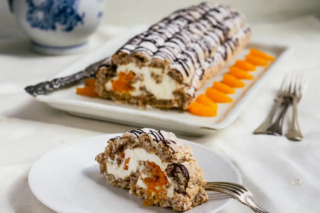 En l&auml;cker Budapest bakelse med aprikoser och gr&auml;dde, dekorerad med choklad och pudersocker.
