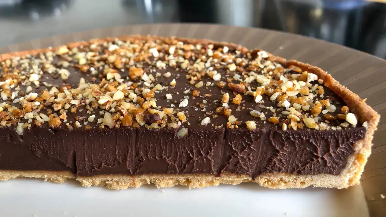Une tranche de tarte au chocolat onctueuse, garnie de noisettes concass&eacute;es. Un d&eacute;lice gourmand !