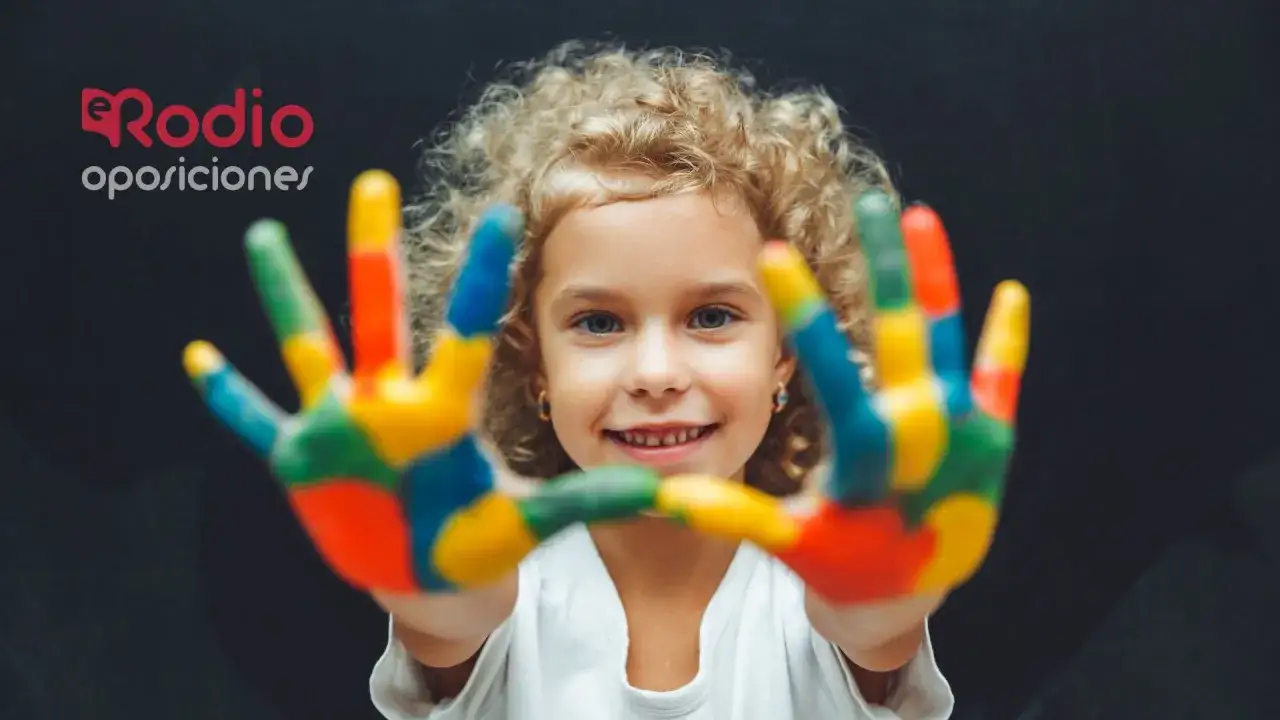 Ni&ntilde;a sonriente con manos pintadas de colores, aprendiendo los lomloe saberes b&aacute;sicos.
