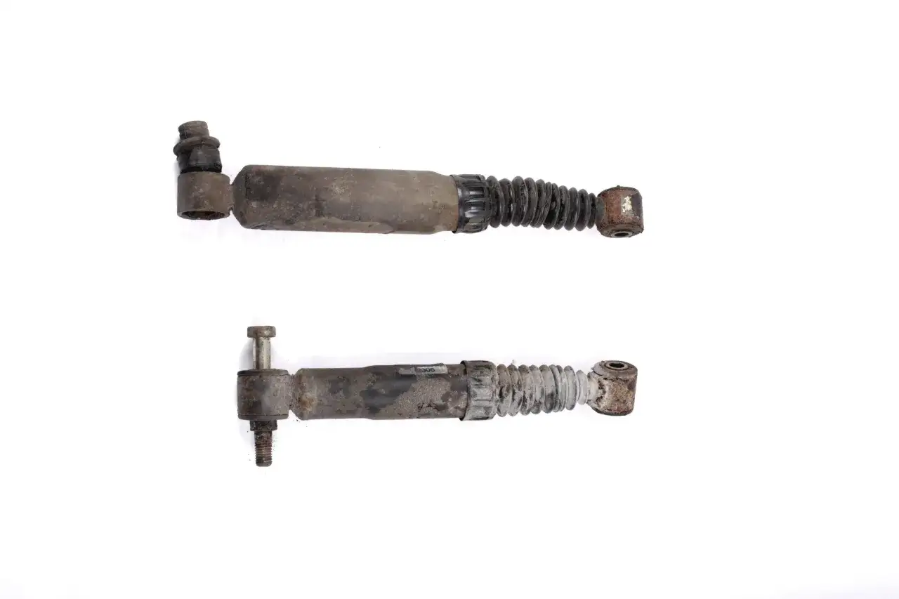 Dwa zużyte amortyzatory samochodowe, gotowe do wymiany amortyzatorów tył.