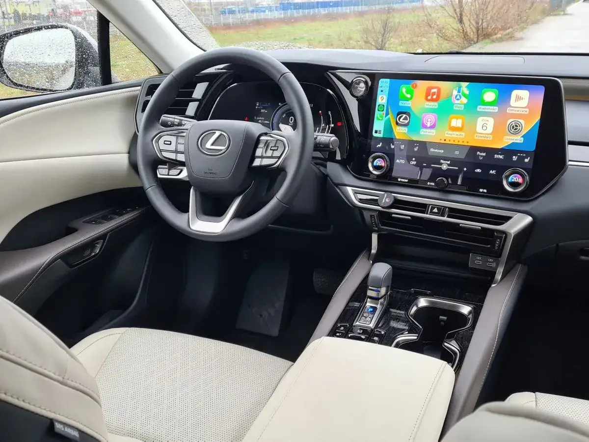 Wnętrze Lexus RX 350 z nowoczesnym ekranem multimedialnym i skórzaną tapicerką.