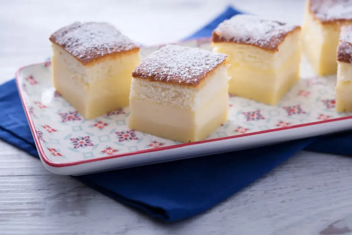 Pastel mágico de capas esponjosas y crema suave, espolvoreado con azúcar glas.