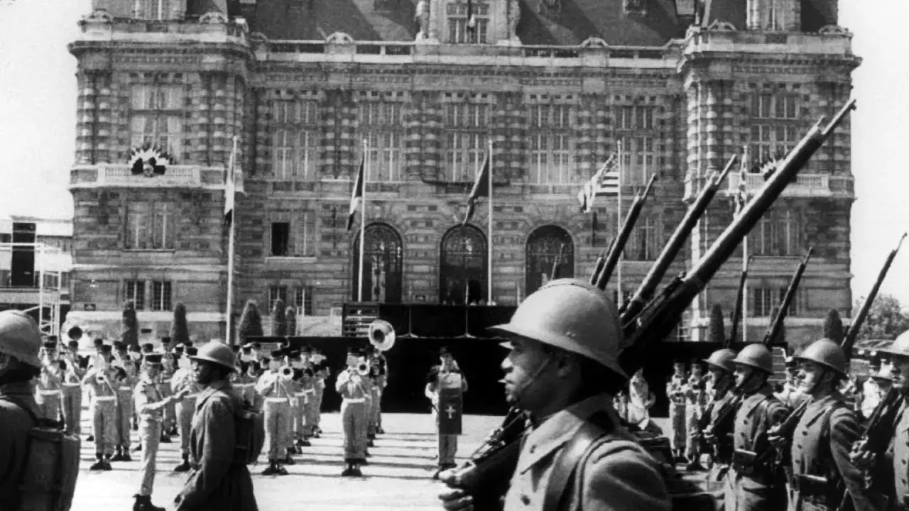 Soldaten stehen vor einem Geb&auml;ude, w&auml;hrend eine Milit&auml;rkapelle spielt. Ein Blick auf die Julikrise.