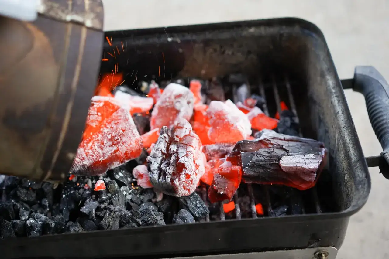 Rozżarzone węgle w grillu, iskry lecą. To początek udanego grillowania, klucz do tego, jak rozpalic grilla.