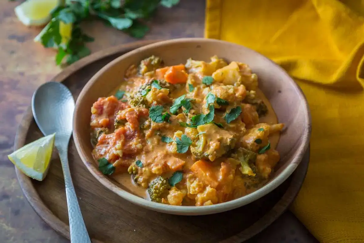 Un savoureux chou-fleur curry crémeux avec des morceaux de brocoli et de carottes, garni de coriandre fraîche.