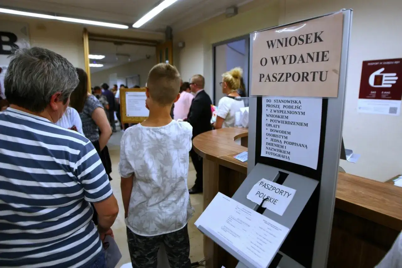 Kolejka do odbioru paszportu. Na tablicy informacja: 