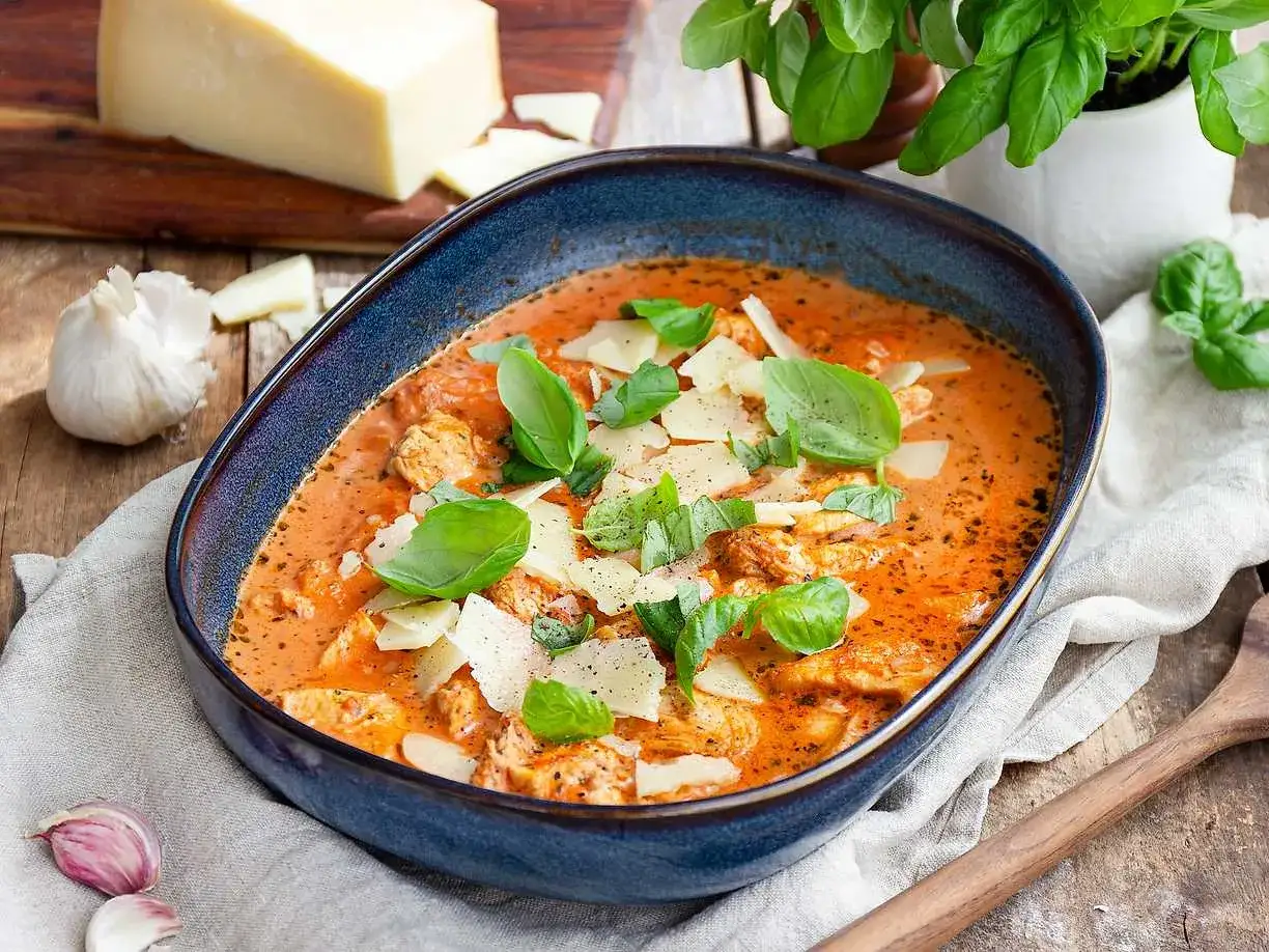 Enkel kyckling i krämig tomatsås, toppad med parmesan och färsk basilika. Ett perfekt kyckling recept enkelt för middagen.