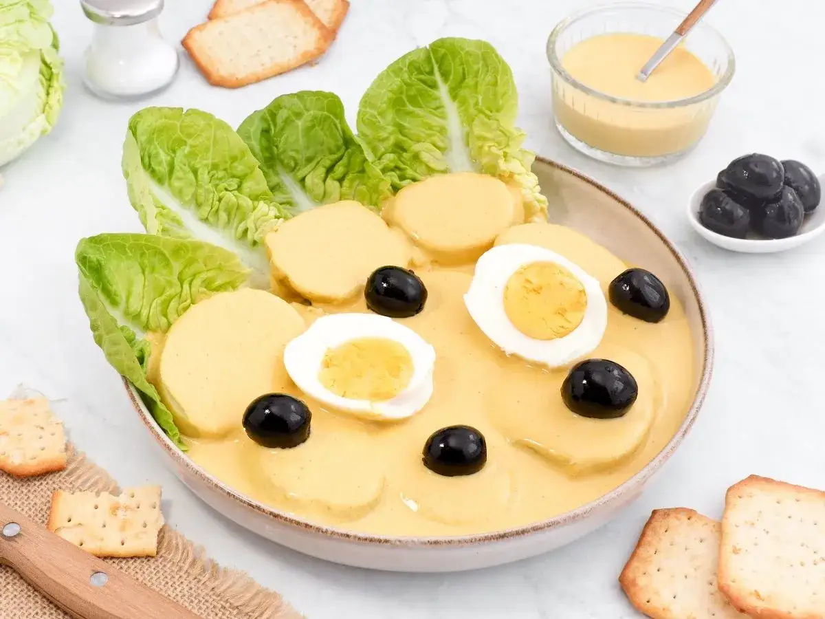 Papa a la huanca&iacute;na: rodajas de papa cubiertas con salsa cremosa, adornadas con huevos duros, aceitunas negras y hojas de lechuga.