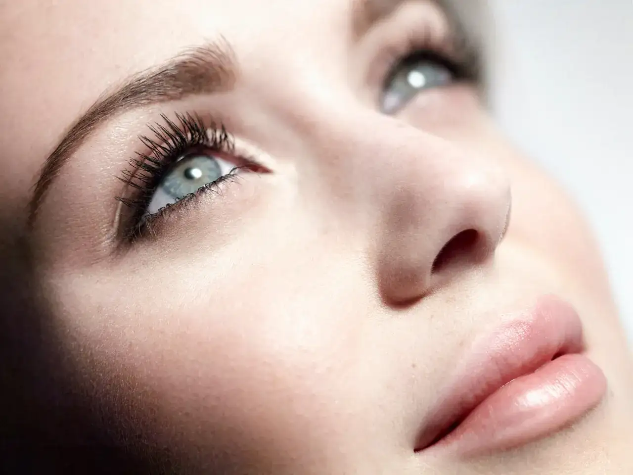Un &oelig;il bleu intense, cils longs et fournis, montre comment mettre du mascara pour un regard de biche.