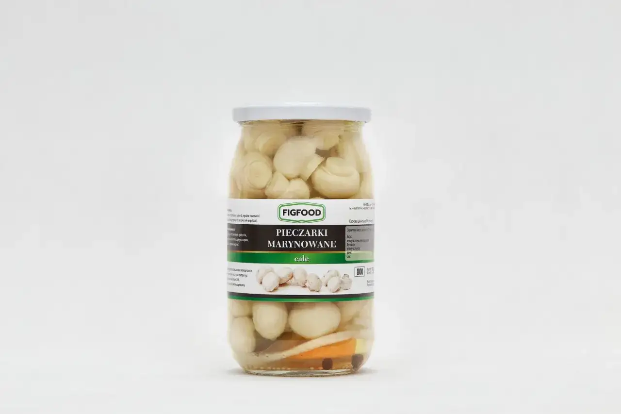Słoik z marynowanymi pieczarkami całymi marki Figfood, z widocznymi kawałkami warzyw.