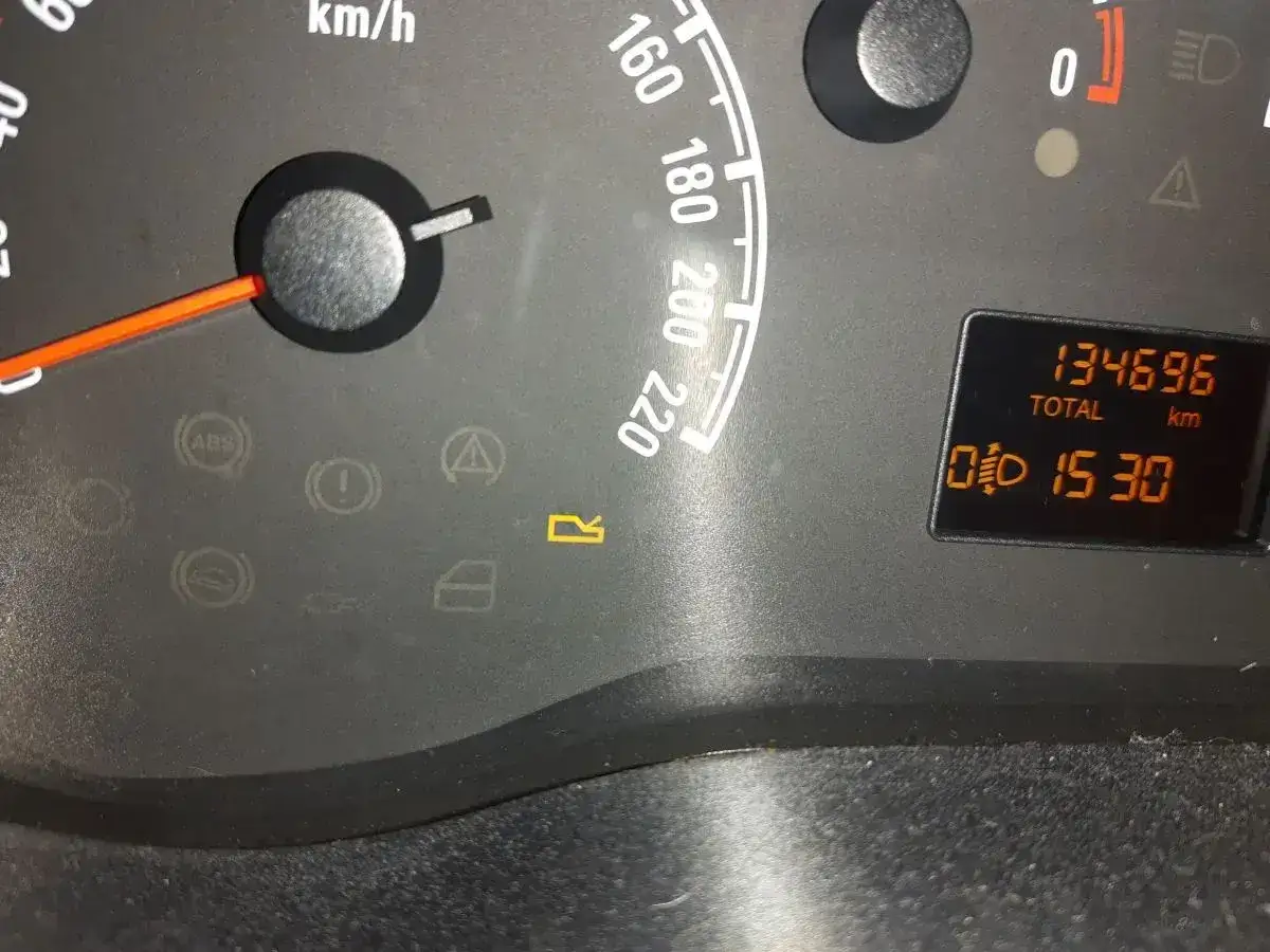 Kontrolki w samochodzie Opel: wskaźnik prędkości, ABS, kontrolka otwartych drzwi, przebieg 134696 km, czas 15:30.